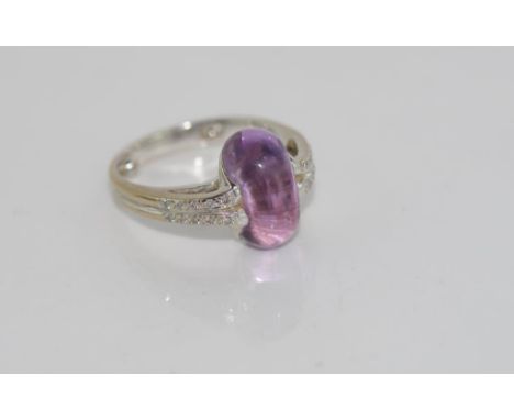 18ct white gold, amethyst and diamond ring jellybean shaped amethyst set between to raised shoulders bead set with diamonds, 