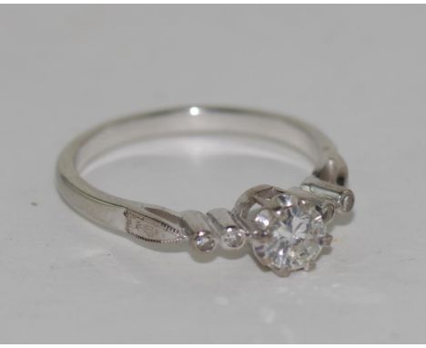 18ct white gold diamond ring with a brilliant cut centre stone, supported with 8 prongs, two rubbed over set small diamonds t