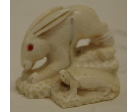 Antique Japanese ivory rabbit netsuke C:1920, carved rabbit with red stone eyes, accompanied by tortoise to base. Signed to b