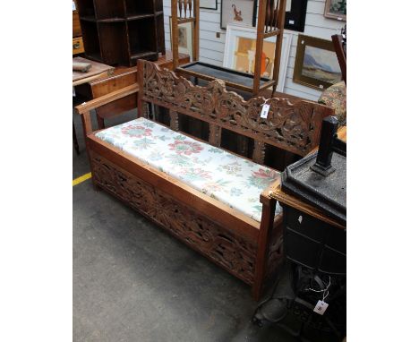 A South Asian style carved hardwood upholstered two seat window sofa. 140cm (W) 