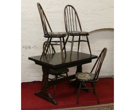 An oak drawleaf dining table and set of four Ercol spindleback dining chairs.