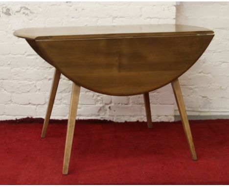 An Ercol Golden Dawn dropleaf dining table raised on tapering supports.