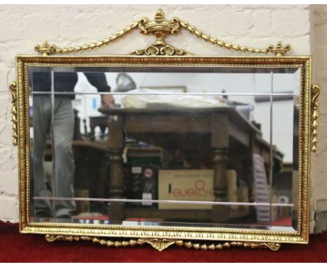 An ornate gilt framed rectangular wall mirror.