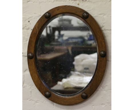 An oak framed oval bevel edged wall mirror.