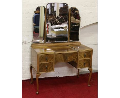 A walnut triple mirror dressing table raised on slender cabriole legs.