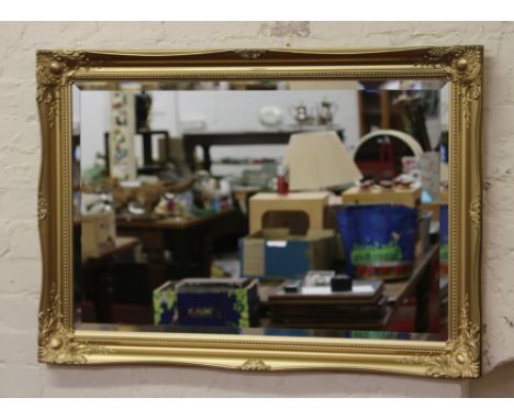 A gilt framed bevel edge wall mirror.