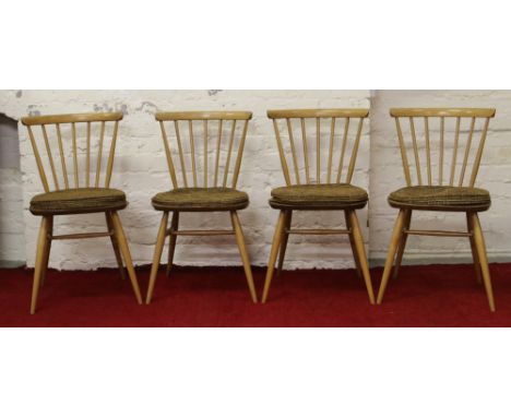 A set of four Ercol light elm spindle back dining chairs.