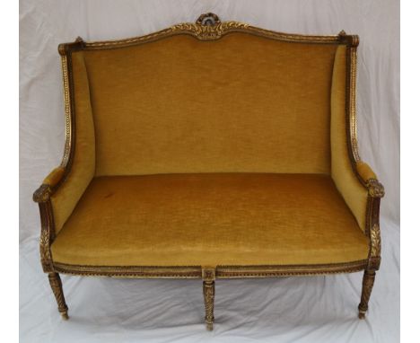 A French gilt decorated two seater settee, with a gilt leaf moulded scrolling back, and leaf terminals to the arms, the back 