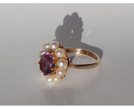 An amethyst and pearl ring, the central oval faceted amethyst approximately 10 x 8mm, surrounded by ten pearls each approxima