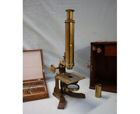 A brass monocular microscope, with rotating mirror, adjustable platform and various lenses, together with a box of slides, ca