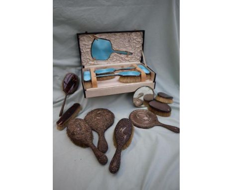 A George V silver and blue enamel part dressing table set, comprising a hand mirror, a pair of hair brushes, and a pair of cl