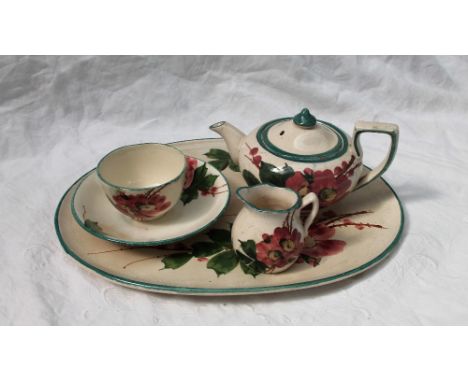 A Llanelly Art Pottery part cabaret set, comprising an oval tray, teapot, cream jug, saucer and sugar basin, printed mark to 