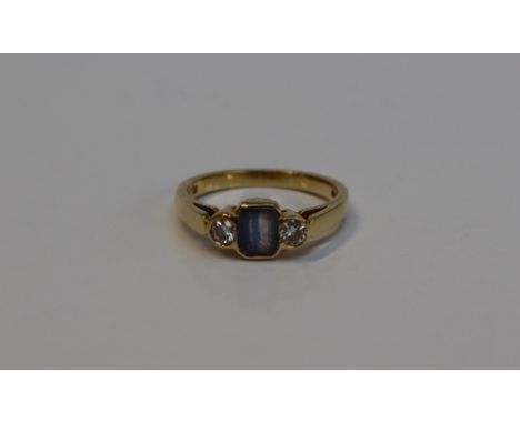 A sapphire and diamond ring, the central light blue sapphire approximately 5mm x 4mm flanked by a pair of round brilliant cut