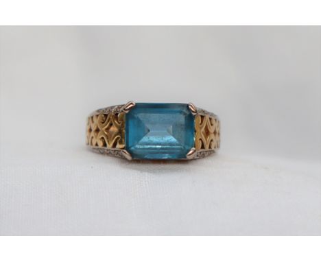 A topaz ring, the emerald cut light blue topaz approximately 10 x 8mm, to a pierced 18ct yellow gold setting and shank, appro