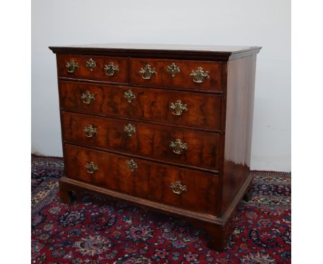 A George I walnut chest, the rectangular top with herringbone banding above two short and three long drawers on ogee bracket 
