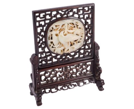 A CHINESE JADE AND HARDWOOD TABLE SCREEN the pale celadon jade oval plaque carved and pierced with a bird amidst lotus set wi