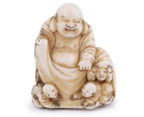 ˜IVORY NETSUKE OF THE LUCKY GOD HOTEI WITH CHILDREN, CIRCA 1870 two of the boys crawling from Hotei's treasure sack, signed: 