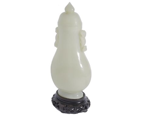 A CHINESE CELADON JADE PEAR-SHAPED VASE AND COVER the flattened pear-shaped body rising from a short spreading foot to a slen