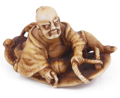 ˜STAINED IVORY NETSUKE OF A NIO ON A GIANT SANDAL, CIRCA 1870 unsigned 4.5cm long Provenance: The Netsuke Collection of Charl