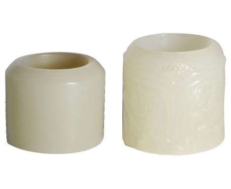 TWO CHINESE JADE ARCHERS RINGS each of cylindrical form, one entirely plain, the other carved in low relief around the exteri