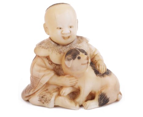˜STAINED WALRUS IVORY NETSUKE OF A BOY SEATED WITH A DOG, CIRCA 1870 the dog's eyes inlaid with dark horn pupils, unsigned 4.