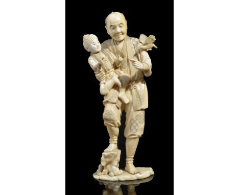 ˜A JAPANESE IVORY OKIMONO OF A FATHER AND SON, GYOKUYUKI, MEIJI PERIOD (1868-1912) sectionally carved as the man rests his so