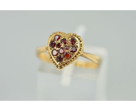 A GARNET RING, the head designed as a heart set with seven circular garnets with beaded edging, stamped 9ct, ring size M, wei