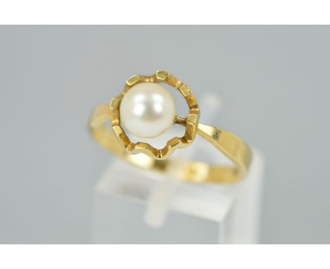 A 9CT GOLD CULTURED PEARL RING designed as a single cultured pearl a top a horizontal within an open scalloped circular base,