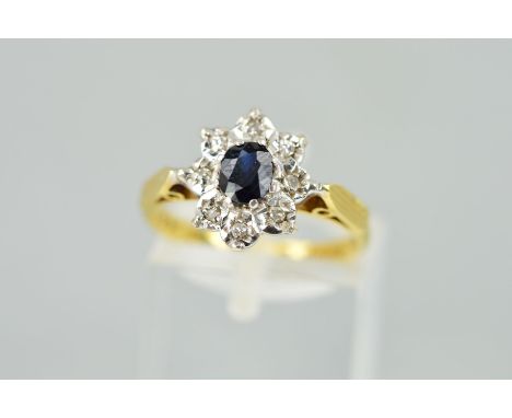 AN 18CT GOLD SAPPHIRE AND DIAMOND CLUSTER RING, designed as an oval sapphire within an illusion set single cut diamond surrou