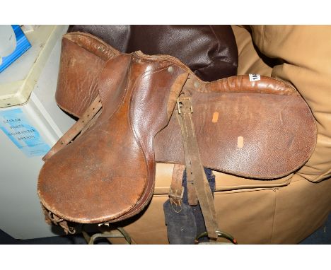 A BROWN LEATHER HORSE SADDLE AND STRIRRUPS and an ercol strick back chair (2)