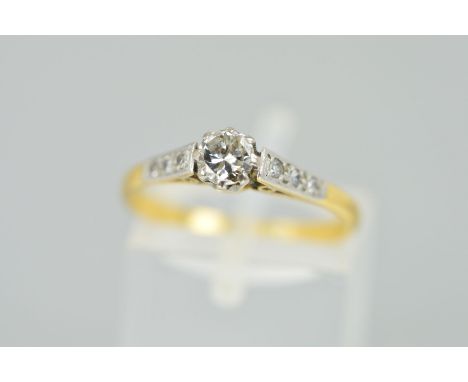 A DIAMOND RING, designed as a brilliant cut diamond within an eight claw setting, the shoulders each set with three single cu
