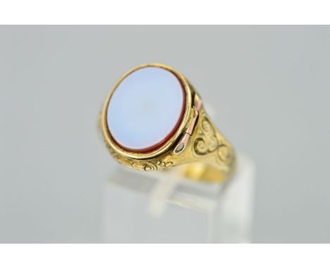 A MID VICTORIAN GOLD POISON/LOCKET RING, designed as an oval chalcedony hinged panel opening to a small compartment with flor