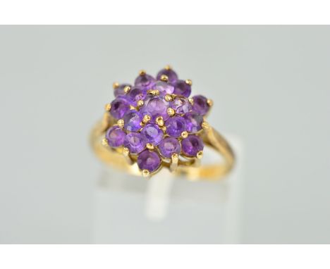 A 9CT GOLD AMETHYST CLUSTER RING designed as a tiered cluster of claw set circular amethyst, hallmarked London 1976, ring siz