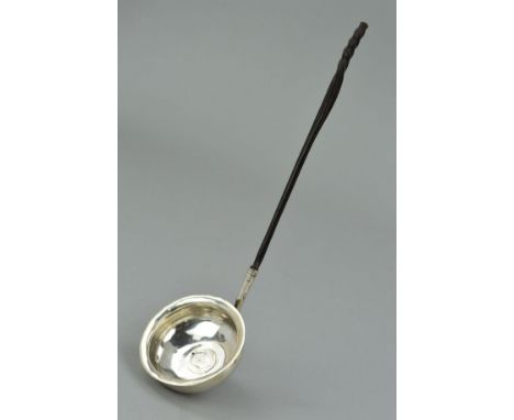 A LATE GEORGIAN SILVER LADLE, the bowl centrally set with an 1818 George III coin with a twisted whale bone handle, s.d., len