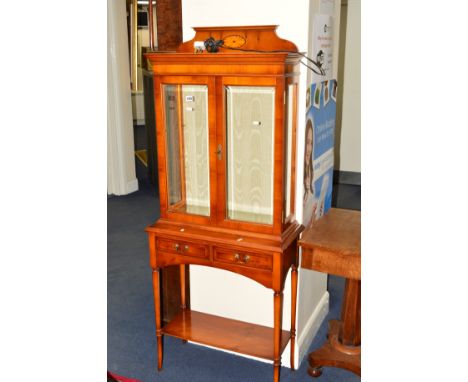 A REPRODUCTION YEW WOOD GLAZED TWO DOOR DISPLAY CABINET, with two drawers on cylindrical tapering legs united by an under she