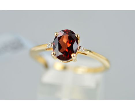 A MODERN 9CT GOLD GARNET AND DIAMOND THREE STONE RING, ring size T 1/2, hallmarked 9ct gold, Birmingham, approximate gross we