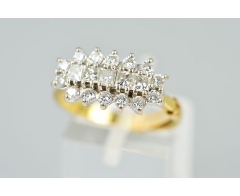 AN 18CT GOLD DIAMOND DRESS RING, designed as a raised row of five princess cut diamonds within a brilliant cut diamond surrou