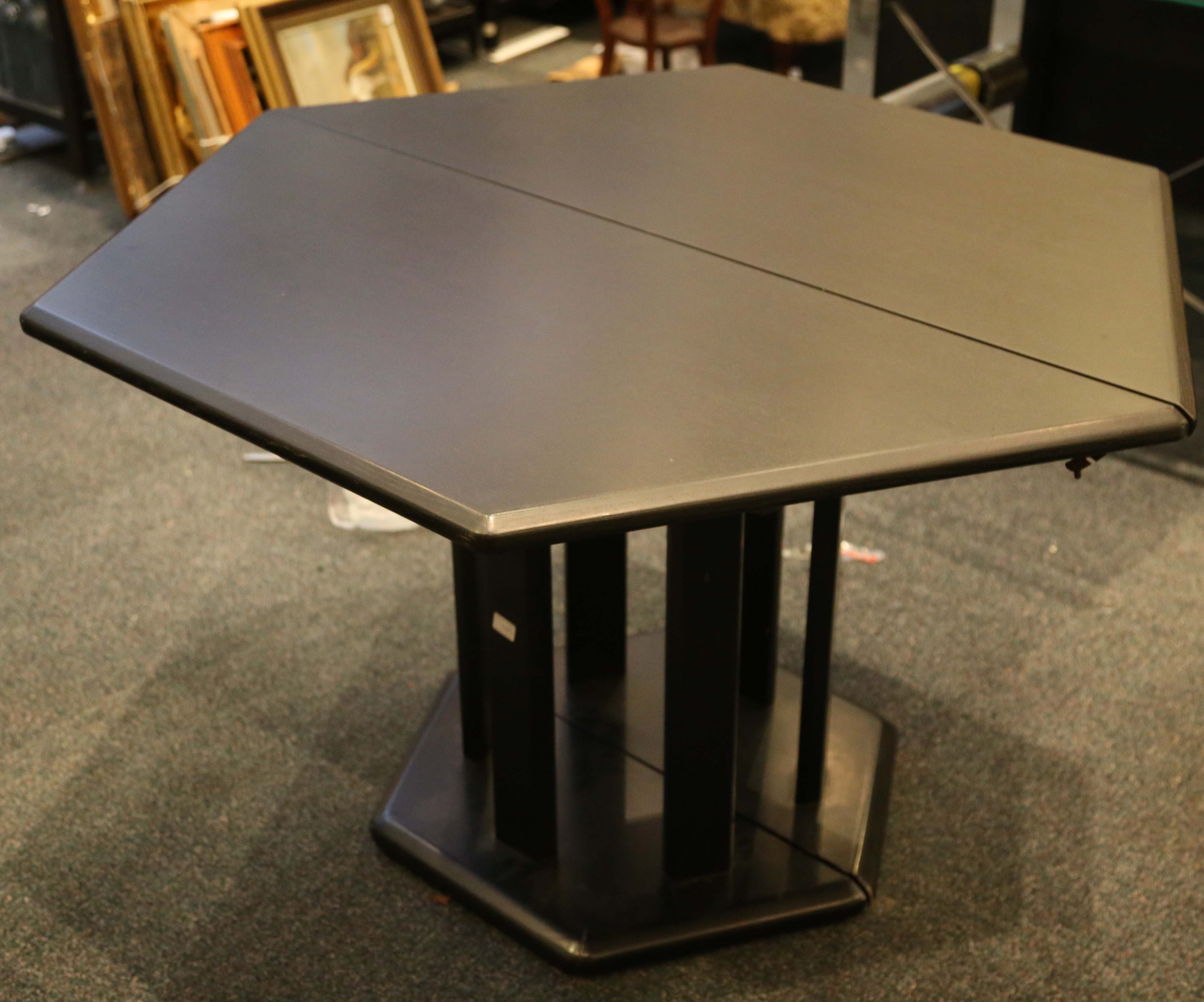 A ebonised hexagonal extending dining table, possibly designed