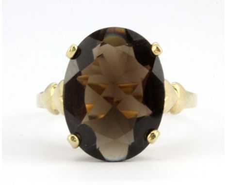 A 9ct yellow gold ring set with an oval cut smokey quartz, (R.5).
