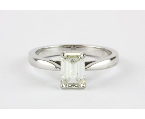 An 18ct white gold (stamped 750) emerald cut diamond set solitaire ring, approx. over 1ct, (K.).