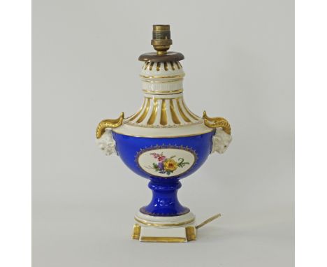 An old German Dresden porcelain table lamp with ram's heads - missing the shade, decorated with sprays of flowers in oval car