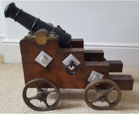 A 19thC cast iron signalling cannon mounted on stepped wooden carriage with iron mounts &amp; bronze wheels, cannon length 12