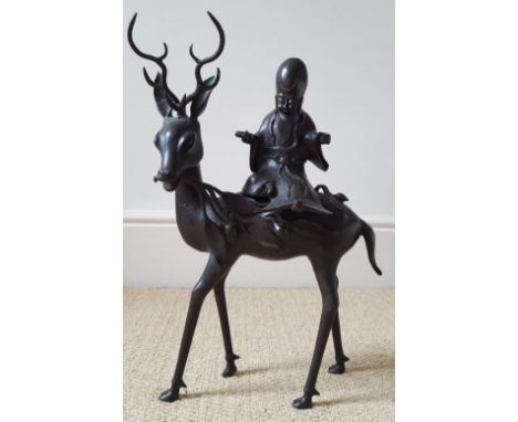 A large Chinese bronze figure group of a wise Immortal seated on a stag, 15.5" high overall.