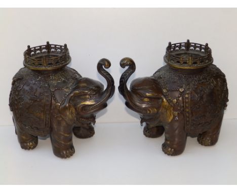 A pair of Japanese Meiji Period patinated bronze elephant incense burners, the pierced circular howdahs separately cast, 9.5"