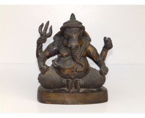 An antique Indian bronze figure of Ganesh, modelled in seated position, holding a steemit and other attributes in each of his