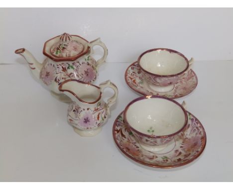 Six pieces of dolls' Victorian tea china decorated in pink lustre flowers, comprising a teapot, cream jug and two cups &amp; 