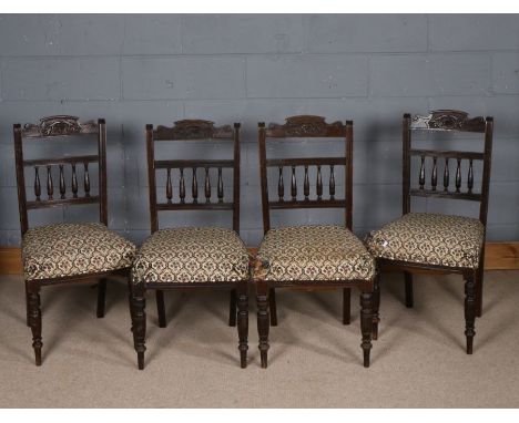 Set of four late Victorian mahogany dining chairs, each carved in relief with flowers and having spindle back rests, floral s