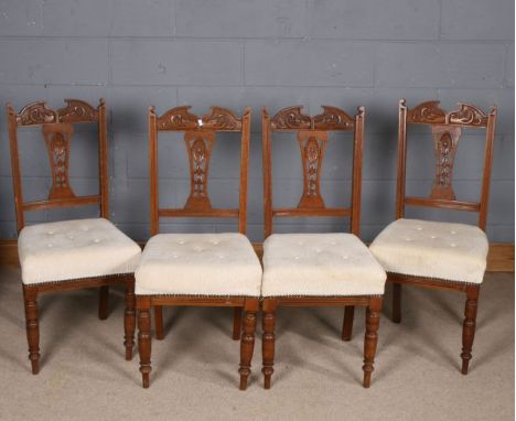 Set of four Art Nouveau oak dining chairs, having swan neck and stylised floral back rest, button down upholstery and raised 