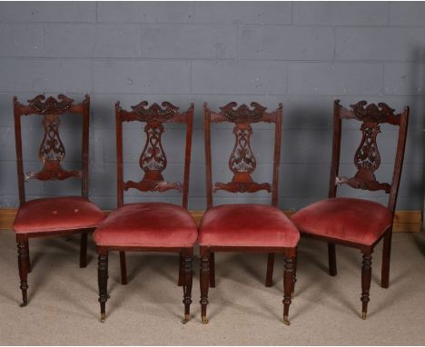 Set of four late Victorian mahogany dining chairs, each with carved pierced splats, raised on ring turned legs and brass cast