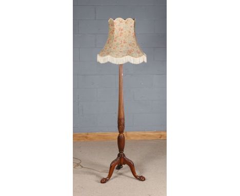 20th century carved mahogany standard lamp, the tapering reeded column raised on three claw on ball feet, with floral shade